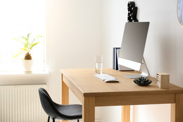 Comfortable workplace with computer on desk in home office