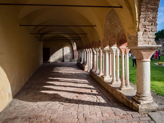 Arched porch with white stone columns in the courtyard of a Benedictine abbey.