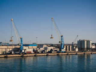Fototapeta na wymiar Shipping industrial trade port. Crane bridge and import export container at shipping port harbor.