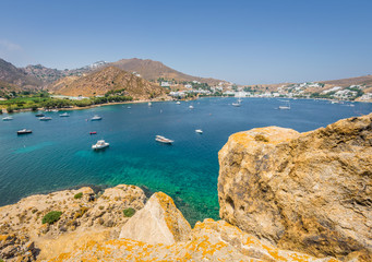 Beautiful sunny holiday coast view to a empty holiday bay with crystal clear blue water sandy greek beach for sunbathing and some boats cruising fishing, Patmos Island, Kos, Dodecanese/ Greece
