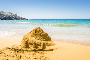 Beautiful sunny coast view to a cozy holiday bay with crystal clear blue water sandy beach for sunbathing and some boats cruising fishing in background, Patmos Island, Dodecanese/ Greece - 07 27 2017