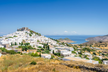 Amazing sunny view from old monastery castle Chora a small greek town near Skala with harbour and...