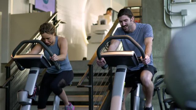 Young man and young woman spinning in a gym