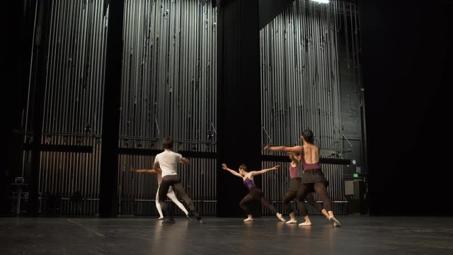 Group of young dancers rehearsing on stage.