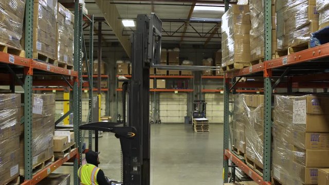 A worker operating a forklift in a warehouse