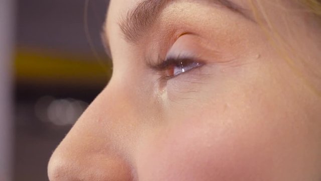 Extreme close up of the female eyes. Professional makeup artist applying mascara on the eyelashes of the model