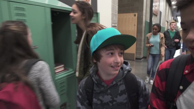 Medium shot of two friends talking on school corridor