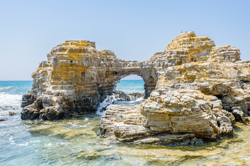 Beautiful sunny coast view to greek beach with rocky arch cove and mediterranean blue sea with...