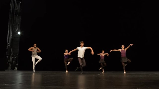 Group of young dancers rehearsing on stage and one dancer slips.