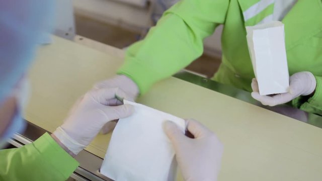 Workers prepackages tea into a paper bags for sale, tea factory