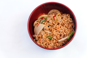 Top view and close up: Instant noodles in red bowl isolated on white background. Spicy taste, street food.