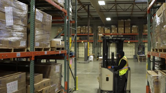 A worker operating a forklift in a warehouse
