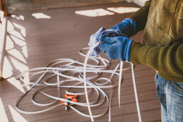 Hands in gloves wipe tape of large tape measure