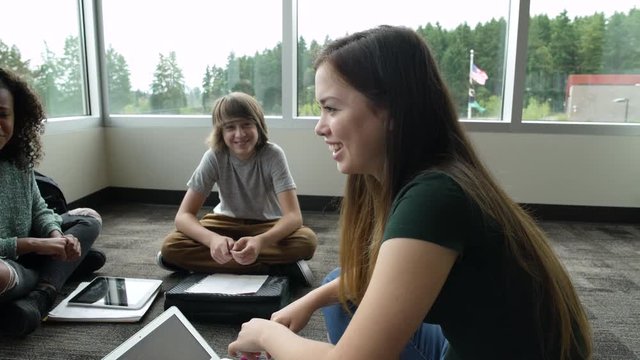 Students talking while sitting together on floor