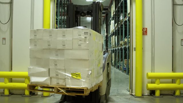 Worker using a forklift in a warehouse