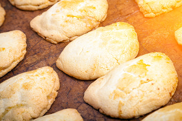 Close-up of fresh delicious freshly baked buns mash with curd in straight rows