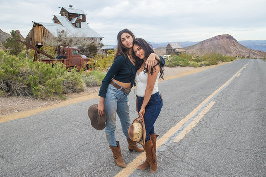 Two pretty country girls on a quiet road in the desert