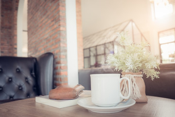 White hot coffee cup on wooden table on green background.