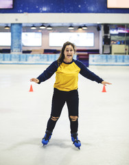 Happy girl ice skating on the rink by herself