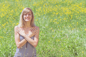Naklejka na ściany i meble Young woman doing yoga on a flowerly meadow.