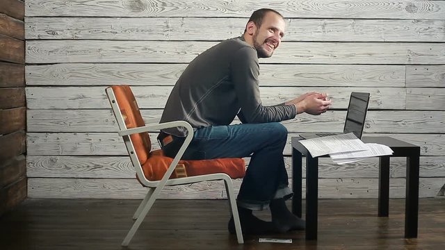 the freelancer working on the computer with the documents gets the bad news