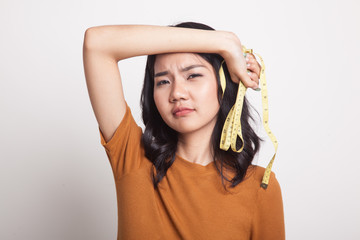 Unhappy young Asian woman with measuring tape.
