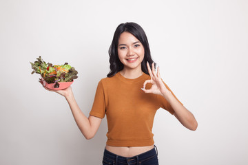 Healthy Asian woman show OK with salad.