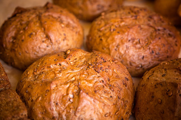 Close-up of fresh white bread in rolls stands in even rows in a bakery