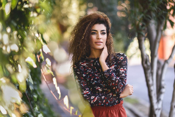 Beautiful young arabic woman with black curly hairstyle.
