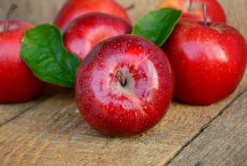 Red apples or Gala apples with fresh leaf and water drop on wooden background