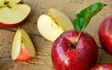 Red apples or Gala apples with fresh leaf and water drop on wooden background.