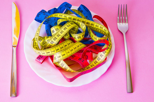 plate with colored metrics and cutlery. diet and slimming concept