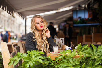 Young woman drinking cocktail in a cafe