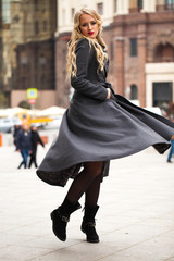 Fototapeta premium Portrait of a young beautiful woman in gray coat