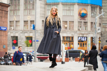 Fototapeta premium Portrait of a young beautiful woman in gray coat