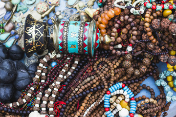 Colorful traditional buddhist souvenirs are sold on the tourist market in Kathmandu, Nepal. Contain of ornaments, small figures, jewelry, statues, masks, prayer whells.