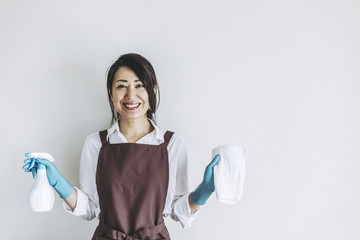 掃除道具を持っている笑顔の主婦