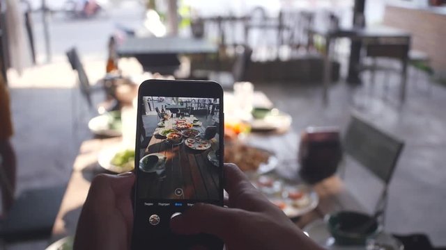 Photographing on the phone a dining table with delicious food, in the sun. slow motion. 1920x1080. full hd