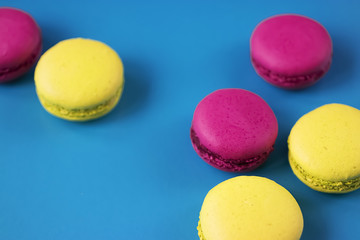 Macaroni cakes on blue background. Copy space.