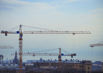 construction cranes over the city in the evening
