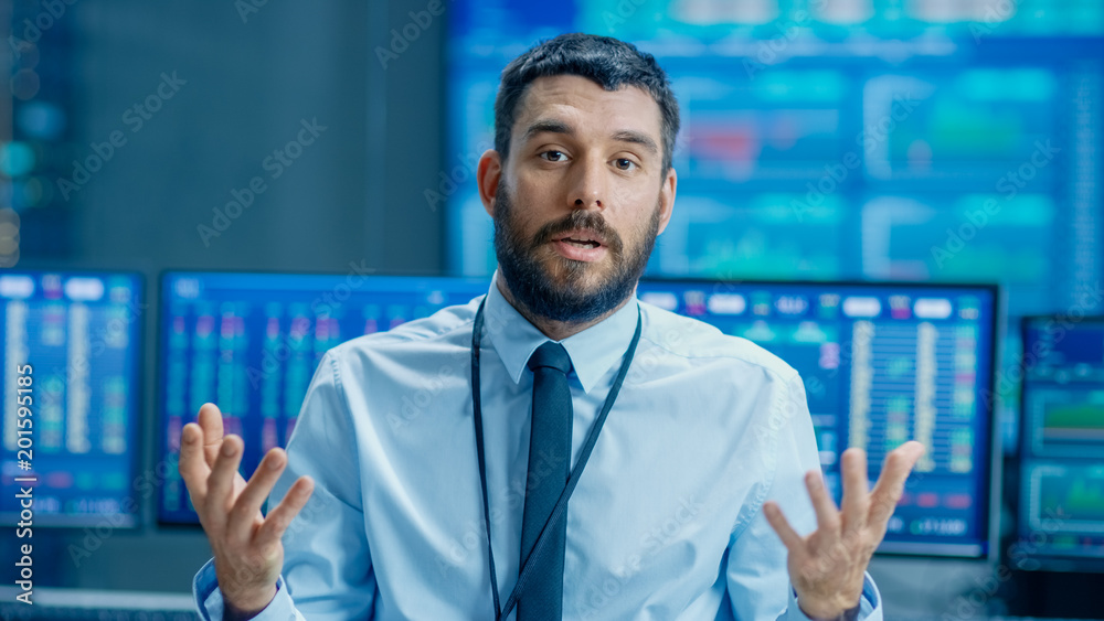 Poster Professional Stock Market Trader Charismatically Talks into the Camera. Behind Him Computer Screens with Ticker Numbers, Data, Graphs.