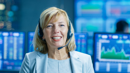 Chief Sales Force Representative Talks into the Headset and Looking into Camera. Behind Her People...