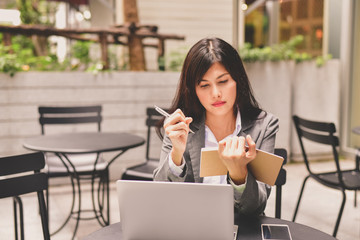 Business Concept.Young Asian businesswoman is working happily.Young businesswoman working in a cafe.Young businesswoman is relaxation in a coffee shop.