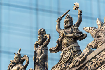 Fototapeta na wymiar Decoration sculpture on Daci buddhist temple roof against modern building in Chengdu, China