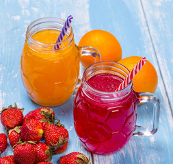 Fresh strawberry and orange cocktailes with fruits on a wooden rustic background.
