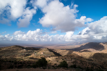 nibi bianche su cielo azzurro e vallata desertica