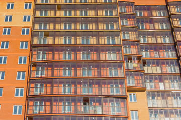 Fototapeta na wymiar A new high-rise building against the blue sky. New building with glazed loggias. New building.