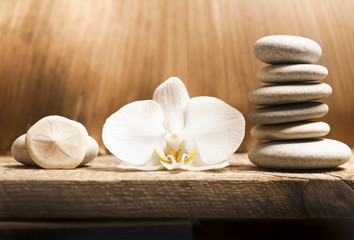 flower and pyramid of stones on a wooden background