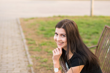 Young girl sitting on bench in park