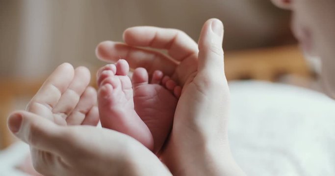 4k, a newborn baby holds a close-up in the mother's hands, slow motion